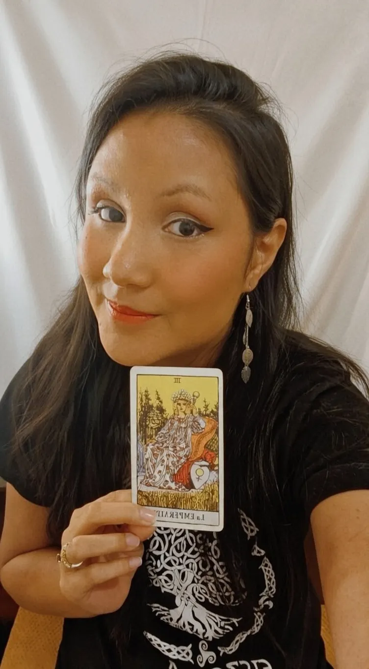 Retrato de Maryana Morgado sentada junto a una mesa con cartas de tarot